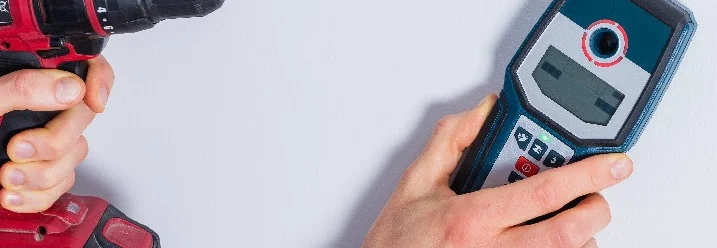 Person verwendet Leitungssucher und Bohrmaschine